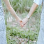 a couple holding hands in a field