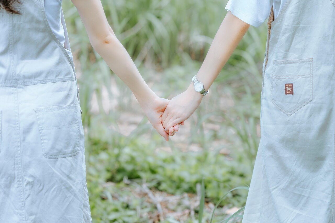 a couple holding hands in a field