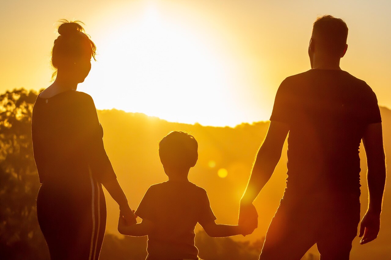 a group of people holding hands and walking in the sun